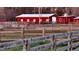 Red barn with white trim and fencing, perfect for livestock or storage at 7027 Old 421 Rd, Liberty, NC 27298