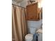 Functional bathroom featuring a neutral shower curtain and wood cabinet at 7027 Old 421 Rd, Liberty, NC 27298