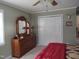 Bedroom with wooden dresser and mirror, complemented by neutral carpet and green walls at 7027 Old 421 Rd, Liberty, NC 27298