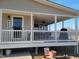 Inviting covered front porch with white railing, ceiling fan, grill, and a welcoming entrance at 7027 Old 421 Rd, Liberty, NC 27298