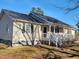 Charming home featuring a porch, white railing, vinyl siding, well-maintained landscaping, and stone accents at 7027 Old 421 Rd, Liberty, NC 27298