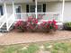 Charming home featuring a beautifully landscaped front yard with vibrant red roses at 7027 Old 421 Rd, Liberty, NC 27298
