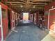 Well-maintained horse barn interior with individual stalls, concrete floor, and abundant lighting at 7027 Old 421 Rd, Liberty, NC 27298