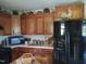Well-equipped kitchen with wooden cabinets, black appliances, ample counter space, and decorative accents at 7027 Old 421 Rd, Liberty, NC 27298