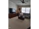 Bright living room features a ceiling fan, a plaid couch, and a wooden entertainment center at 7027 Old 421 Rd, Liberty, NC 27298