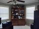 Well-lit home office with a large bookcase filled with trophies and memorabilia at 7027 Old 421 Rd, Liberty, NC 27298