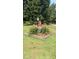 Charming yard decor with an American flag, flowers, statue, and mature trees, adding character to the landscape at 7027 Old 421 Rd, Liberty, NC 27298