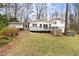 Spacious backyard with a deck, outdoor seating, a hot tub, and mature trees, creating a relaxing retreat at 705 Greencove Ct, Raleigh, NC 27609