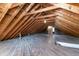 Unfinished attic space with wooden beams, a wood floor, and a brick chimney extending to the ceiling at 708 S Layton Ave, Dunn, NC 28334