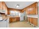 Classic kitchen featuring wood cabinets, laminate countertops, and matching white appliances at 708 S Layton Ave, Dunn, NC 28334