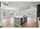 Open kitchen and living room has pendant lights over island, stainless appliances, and hardwood floors at 749 Aristocrat Ln, Knightdale, NC 27545