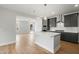 Bright kitchen with island features gray cabinets, stainless appliances, a white backsplash, and pendant lights at 749 Aristocrat Ln, Knightdale, NC 27545