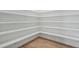 Walk-in pantry features wood-look flooring and white shelves at 749 Aristocrat Ln, Knightdale, NC 27545