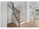 Stylish staircase with wooden handrail, black iron balusters, and hardwood flooring, leading upstairs at 749 Aristocrat Ln, Knightdale, NC 27545