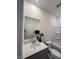 Bright bathroom features single sink, large mirror, modern lighting, wood-look flooring, toilet, and bathtub at 813 Emmer St, Rolesville, NC 27571