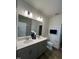 Bright bathroom features dual sinks, large mirror, modern lighting, wood-look flooring, and toilet at 813 Emmer St, Rolesville, NC 27571
