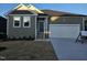Charming single Gathering home with white garage door, green siding, and well manicured front yard at 813 Emmer St, Rolesville, NC 27571