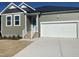 Charming single Gathering home with white garage door, green siding, and well manicured front yard at 813 Emmer St, Rolesville, NC 27571