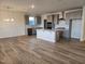 Open-concept kitchen features gray cabinets, subway tile backsplash, stainless appliances, and a center island with pendant lighting at 813 Emmer St, Rolesville, NC 27571