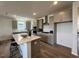 Beautiful eat-in kitchen with large island, modern appliances, light gray cabinets, and modern lighting at 813 Emmer St, Rolesville, NC 27571