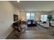 Bright living room features hardwood floors, modern furniture, neutral color palette, and view of backyard at 813 Emmer St, Rolesville, NC 27571
