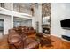 Bright living room with stone fireplace, leather furniture, hardwood floors, and access to the outdoor space at 8717 Carradale Ct, Wake Forest, NC 27587