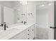 Modern bathroom featuring double sinks, sleek black hardware, and white cabinetry, leading into a carpeted bedroom at 9169 Dupree Meadow Dr # 26, Angier, NC 27501