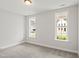 Bright bedroom with plush carpet, neutral walls, and two sunlit windows framing picturesque neighborhood views at 9169 Dupree Meadow Dr # 26, Angier, NC 27501