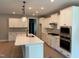 Modern kitchen featuring white cabinets, quartz countertops, and stainless steel appliances, perfect for cooking at 9169 Dupree Meadow Dr # 26, Angier, NC 27501