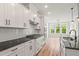 Open concept kitchen with stainless steel appliances, white cabinets, dark granite countertops, and a bright dining area at 9169 Dupree Meadow Dr # 26, Angier, NC 27501