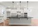 Spacious kitchen featuring a large island with granite countertop, white cabinets, and modern pendant lighting at 9169 Dupree Meadow Dr # 26, Angier, NC 27501