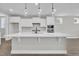 Bright kitchen with white cabinets, a large island, modern pendant lighting, and stainless appliances at 9169 Dupree Meadow Dr # 26, Angier, NC 27501