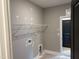Functional laundry room with shelving, utility connections, and a black door at 9169 Dupree Meadow Dr # 26, Angier, NC 27501
