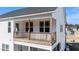 View of the balcony with wood railings and columns, showing access to the upper level of the home at 99 Bodacious Ln, Benson, NC 27504