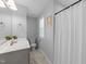 Bright bathroom featuring a toilet, tub with shower curtain, a vanity with sink, and grey tile floors at 99 Bodacious Ln, Benson, NC 27504