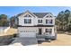 Charming two-story home with a two-car garage, a welcoming front porch, and attractive black and white exterior details at 99 Bodacious Ln, Benson, NC 27504