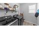Modern laundry room with sleek washer and dryer, shelving and dark patterned floor at 99 Bodacious Ln, Benson, NC 27504