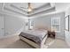 Bright main bedroom with natural light, a tray ceiling, and a door leading to a private balcony at 99 Bodacious Ln, Benson, NC 27504