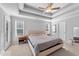 Bright main bedroom featuring a ceiling fan, tray ceiling, neutral color palette, and carpet flooring at 99 Bodacious Ln, Benson, NC 27504