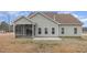 Rear exterior view, highlighting a screened patio next to a concrete patio at 100 Blooms Way, Kenly, NC 27542