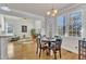 A dining room features a table set for four, and a chandelier light fixture at 1009 River Commons Dr, Knightdale, NC 27545