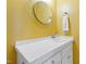 Bathroom with single sink, white tile counter, and yellow walls at 101 S Bloodworth St, Raleigh, NC 27601