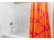 Bright bathtub and shower feature white tiles and an orange shower curtain with pink geometric patterns at 101 S Bloodworth St, Raleigh, NC 27601