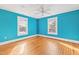 Bedroom painted in a vibrant blue color, features hardwood floors, a ceiling fan, and two windows at 101 S Bloodworth St, Raleigh, NC 27601