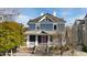 Charming two-story home featuring a welcoming front porch, gray siding and a vibrant pink front door at 101 S Bloodworth St, Raleigh, NC 27601