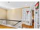 Bright hallway featuring hardwood floors, a white railing, and natural light at 101 S Bloodworth St, Raleigh, NC 27601