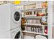 Efficient laundry area with stackable washer and dryer, plus shelving for optimal storage at 101 S Bloodworth St, Raleigh, NC 27601