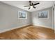 Spacious bedroom with hardwood floors, a ceiling fan, and two windows that offer natural light at 106 Woodland Dr, Cary, NC 27513