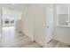 Hallway with modern floors leads to a staircase and sunlit living spaces at 107 Willow Cameron Way, Angier, NC 27501