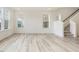 Hallway with stairs to the left and sun-filled rooms showcasing vinyl plank flooring at 107 Willow Cameron Way, Angier, NC 27501